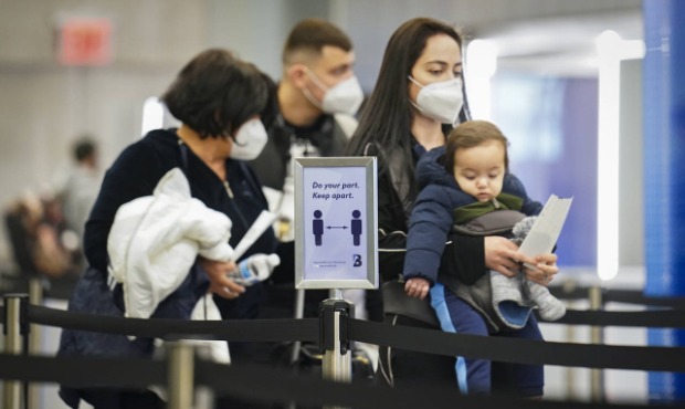 Travelers move through a security checkpoint in a sparsely populated terminal at LaGuardia Airport,...