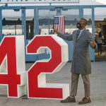 Los Angeles County Registrar-Recorder/County Vote Center Lead Justin Ogunji, right, stands by the No. 42 display outside of Dodger Stadium, as he calls for the vote center at the stadium to open on Election Day, Tuesday morning, Nov. 3, 2020, in Los Angeles. (AP Photo/Damian Dovarganes)