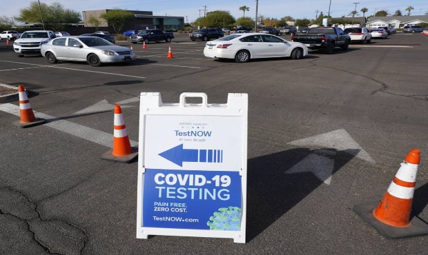 Vehicles line up at patrons wait for COVID-19 tests at a drive-thru testing center Tuesday, Dec. 8,...