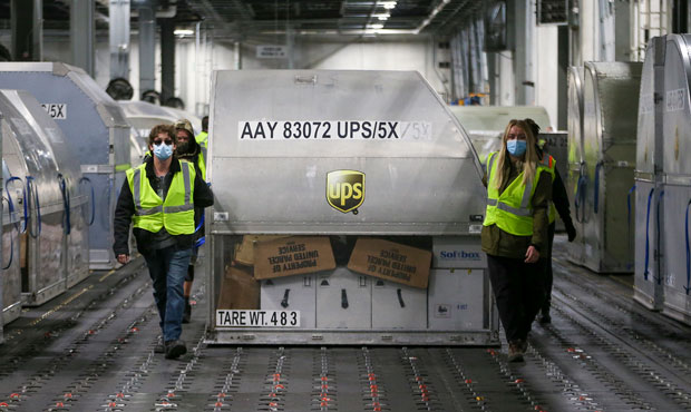 UPS employees move one of two shipping containers containing the first shipments of the Pfizer and ...
