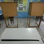 
              A voter is seen behind a polling booth as casts a vote at a polling station during the parliamentary elections in Deftera, a suburb of capital Nicosia, Cyprus, Sunday, May 30, 2021. Cypriots are voting for a new parliament, with some 558,000 voters eligible to elect 56 lawmakers. (AP Photo/Petros Karadjias)
            