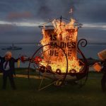 
              A person dressed as British Prime Minister Boris Johnson and a person dressed with a fuel can on their head, from Ocean Rebellion, set fire to a boat in St. Ives, during the G7 summit in Cornwall, England Friday, June 11, 2021. (Ben Birchall/PA via AP)
            