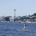 
              A person rides on a paddle board on Lake Union during a heat wave hitting the Pacific Northwest, Sunday, June 27, 2021, in Seattle. Yesterday set a record high for the day with more record highs expected today and Monday. (AP Photo/John Froschauer)
            