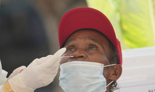 A health worker collects a nasal swab from a man for a coronavirus test in Bangkok, Thailand, Tuesd...