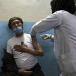
              A man receives the Sinopharm COVID-19 vaccine at a vaccination center, in Kabul, Afghanistan, Wednesday, June 16, 2021. In Afghanistan, where a surge threatens to overwhelm a war-battered health system, 700,000 doses donated by China arrived over the weekend, and within hours, "people were fighting with each other to get to the front of the line," said Health Ministry spokesman Dr. Ghulam Dastigir Nazari. (AP Photo/Rahmat Gul)
            
