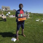 
              Protestors, demonstrating for various causes, hold signs on a hillside outside the G7 meeting in St. Ives, Cornwall, England, Sunday, June 13, 2021. Leaders of the G7 wrap up three days of meetings in Carbis Bay Sunday, in which they discussed such topics as COVID-19, climate, foreign policy and the economy. (AP Photo/Jon Super)
            