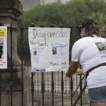 
              Family of Ricardo Valdes, who disappeared on the road on May 25, placed missing posters during a protest in Monterrey, Nuevo Leon state, Mexico, Thursday, June 24, 2021. As many as 50 people in Mexico are missing after they set off on simple highway trips between the industrial hub of Monterrey and the border city of Nuevo Laredo; relatives say they simply disappeared on the heavily traveled road, which has been dubbed 'the highway of death,' never to be seen again. (AP Photo/Roberto Martinez)
            