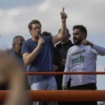 
              Brazil's Environment Minister, Ricardo Salles talks to supporters at the end of a caravan of motorcycle enthusiasts, organized to show support for President Jair Bolsonaro, in Sao Paulo, Brazil, Saturday, June 12, 2021. (AP Photo/Marcelo Chello)
            