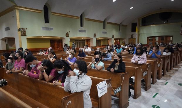 People pray, late Saturday, June 26, 2021, during a prayer vigil for the victims and families of th...