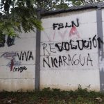 
              A wall that is defaced with graffiti with one message that once read in Spanish: "Resist Nicaragua", was overpainted by another that now reads "Long live the Nicaraguan revolution", in Managua, Nicaragua, Thursday, June 17, 2021. In recent weeks, Nicaragua President Daniel Ortega's government has rounded up 13 opposition leaders, including four presidential challengers for the Nov. 7 elections. They face allegations ranging from money laundering to crimes against the state. (AP Photo/Miguel Andres)
            