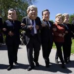 
              Activists dressed in giant papier-mache heads depicting G7 leaders participate in a march during a demonstration around the meeting of the G7 in Falmouth, Cornwall, England, Saturday, June 12, 2021. Leaders of the G7 gather for a second day of meetings on Saturday, in which they will discuss COVID-19, climate, foreign policy and the economy. Leaders depicted from left, Japan's Prime Minister Yoshihide Suga, French President Emmanuel Macron, British Prime Minister Boris Johnson, Italy's Prime Minister Mario Draghi, German Chancellor Angela Merkel, U.S. President Joe Biden and Canadian Prime Minister Justin Trudeau. (AP Photo/Alberto Pezzali)
            
