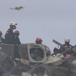 
              Search and rescue personnel search for survivors through the rubble with the aid of a drone at the Champlain Towers South Condo as thick smoke from a fire within the rubble fills the air in Surfside, Fla., Friday, June 25, 2021. The apartment building partially collapsed on Thursday, June 24. (AP Photo/Wilfredo Lee)
            