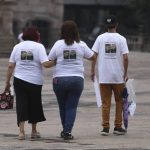 
              Family members wear T-shirts with photos of disappeared Jorge Arevelo and Ricardo Valdes, during a protest in Monterrey, Nuevo Leon state, Mexico, Thursday, June 24, 2021. As many as 50 people in Mexico are missing after they set off on simple highway trips between the industrial hub of Monterrey and the border city of Nuevo Laredo; relatives say they simply disappeared on the heavily traveled road, which has been dubbed ‘the highway of death,’ never to be seen again. (AP Photo/Roberto Martinez)
            