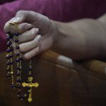 
              A young woman holds a rosary as she prays, late Saturday, June 26, 2021, during a prayer vigil for the victims and families of the Champlain Towers collapsed building in Surfside, Fla., at the nearby St. Joseph Catholic Church in Miami Beach, Fla. Many people were still unaccounted for two days after Thursday's fatal collapse. (AP Photo/Wilfredo Lee)
            