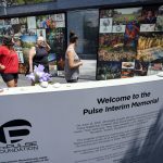 
              Visitors pay tribute to the display outside the Pulse nightclub memorial Friday, June 11, 2021, in Orlando, Fla. Saturday will mark the fifth anniversary of the mass shooting at the site. (AP Photo/John Raoux)
            