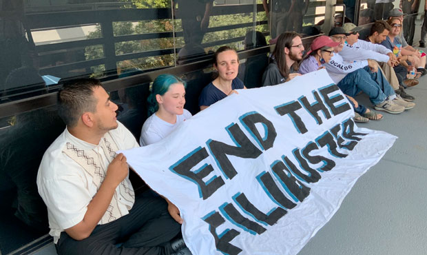 Ten people were arrested on June 22, 2021, during an anti-filibuster protest outside Sen. Kyrsten S...