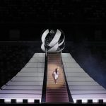 
              Naomi Osaka climbs stairs to light the Olympic Cauldron during the opening ceremony in the Olympic Stadium at the 2020 Summer Olympics, Friday, July 23, 2021, in Tokyo, Japan. (AP Photo/Kirsty Wigglesworth)
            