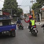 Motorcycle volunteers clear traffic for an ambulance carrying the body of a COVID-19 victim on its way to a cemetery for burial, in Bekasi on the outskirts of Jakarta, Indonesia on July 11, 2021. The two-wheeled volunteers provide a key service in the sprawling metropolis, one in more need than ever as ambulances struggle to serve all those in need because of a surge in coronavirus infections and deaths. (AP Photo/Achmad Ibrahim)