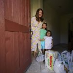 
              In this July 21, 2021, photo, Cynthia Carrasco White and her daughters, Charlotte, 6 and Mathilde, 3 receive a Walmart purchase delivered by Instacart at their front door home in the Porter Ranch area of Los Angeles. Carrasco White, a single mother and a lawyer for a Los Angeles nonprofit, used to think delivery was a luxury she couldn't afford. But she started getting meals, groceries and other necessities delivered last year so she could avoid taking her young, unvaccinated daughters to the store.White has come to see delivery as a lifeline that saves her time, gas money and child care expenses. She uses various apps, including Uber Eats and DoorDash, and takes advantage of deals when she can. (AP Photo/Damian Dovarganes)
            
