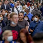 
              People, some with face masks and some without, walk on a main shopping street in Frankfurt, Germany, Wednesday, July 14, 2021. (AP Photo/Michael Probst)
            