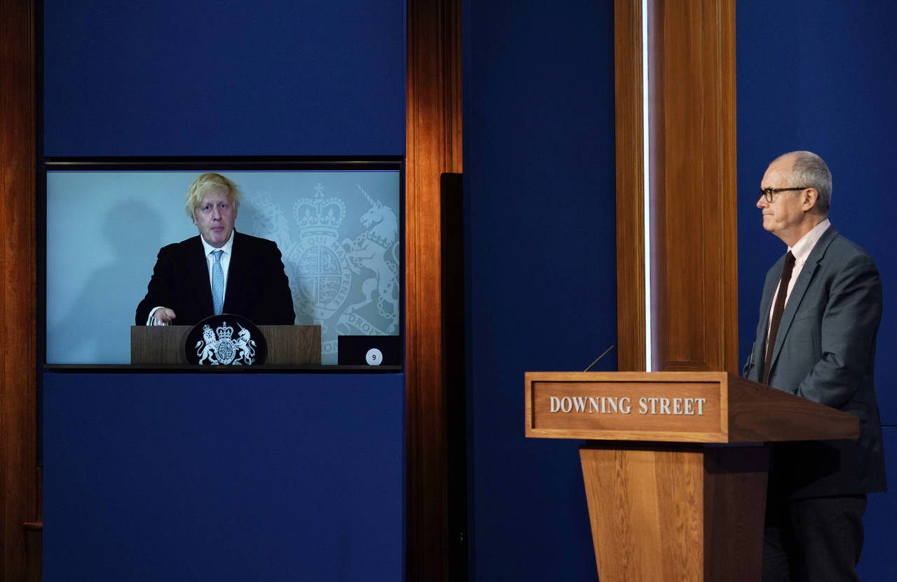 
              Britain's Prime Minister Boris Johnson at left on a screen from Chequers, the country house of the Prime Minister where he is self-isolating, with Chief Scientific Advisor Patrick Vallance, right, in Downing Street, London, attend a media briefing on coronavirus on Monday July 19, 2021. (AP Photo/Alberto Pezzali)
            