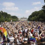 
              Thousands of people take part in the Christopher Street Day (CSD) parade, with the Brandenburg Gate in the background in Berlin, Germany, Saturday July 24, 2021.  (Jorg Carstensen/dpa via AP)
            
