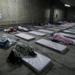
              Homeless people sleep on mattresses laid out by the government inside a subway station amid historically cold weather in Sao Paulo, Brazil, early Friday, July 30, 2021. The Brazilian government's meteorological institute says low temperatures should endure until the start of August. (AP Photo/Marcelo Chello)
            