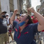 
              A woman shouts pro-government slogans as anti-government protesters march in Havana, Cuba, Sunday, July 11, 2021. Hundreds of demonstrators took to the streets in several cities in Cuba to protest against ongoing food shortages and high prices of foodstuffs. (AP Photo/Ismael Francisco)
            