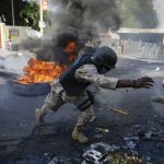 
              Police clear barricades of burning tires set by protesters upset with growing violence in the Lalue neighborhood of Port-au-Prince, Haiti, Wednesday, July 14, 2021, a week after Haitian President Jovenel Moise was assassinated in his home. (AP Photo/Joseph Odelyn)
            