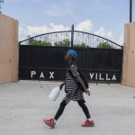 
              A woman walks past the entrance of the mortuary where the body of President Jovenel Moise was transferred to, in Port-au-Prince, Haiti, Saturday, July 10, 2021, three days after President Jovenel Moise was assassinated in his home . (AP Photo / Joseph Odelyn)
            