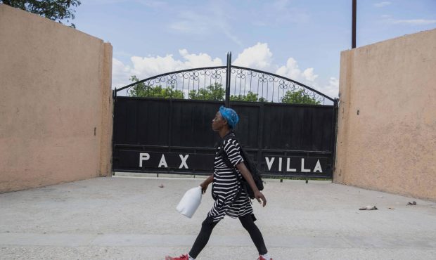 A woman walks past the entrance of the mortuary where the body of President Jovenel Moise was trans...