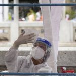 
              A Health worker disinfects plastic sheets after collecting nasal swabs from local residents for coronavirus testing in Bangkok, Thailand, Thursday, July 8, 2021. (AP Photo/Sakchai Lalit)
            