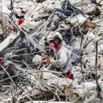 
              A search and rescue team member moves through the rubble of the Champlain Towers South condo, Wednesday, July 7, 2021. (Al Diaz/Miami Herald via AP)
            