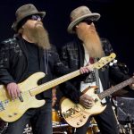 
              FILE - Dusty Hill, left, and Billy Gibbons from U.S rock band ZZ Top perform at the Glastonbury music festival in Somerset, England, June 24, 2016. ZZ Top has announced that Hill, one of the Texas blues trio's bearded figures and bassist, has died at his Houston home. He was 72. In a Facebook post, bandmates Billy Gibbons and Frank Beard revealed Wednesday, July 28, 2021, that Hill had died in his sleep. (Photo by Jonathan Short/Invision/AP, File)
            