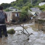 
              A man watches as rescuers continue a search operation at the site of a mudslide at Izusan in Atami, Shizuoka prefecture, southwest of Tokyo Monday, July 5, 2021. (Kyodo News via AP)
            
