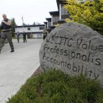 
              Cadets LeAnne Cone, left, of the Vancouver Police Dept., and Kevin Burton-Crow, right, of the Thurston Co. Sheriff's Dept., walk past a rock at the Washington state Criminal Justice Training Commission engraved with "WSCJTC Values Professionalism, Accountability Integrity," on the way to a training exercise Wednesday, July 14, 2021, in Burien, Wash. Washington state is embarking on a massive experiment in police reform and accountability following the racial justice protests that erupted after George Floyd's murder last year, with nearly a dozen new laws that took effect Sunday, July 25, but law enforcement officials remain uncertain about what they require in how officers might respond — or not respond — to certain situations, including active crime scenes and mental health crises. (AP Photo/Ted S. Warren)
            