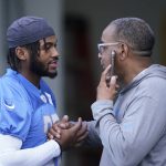 
              Detroit Lions running back D'Andre Swift greets team security director Elton Moore before drills at the Lions NFL football camp practice, Wednesday, July 28, 2021, in Allen Park, Mich. (AP Photo/Carlos Osorio)
            