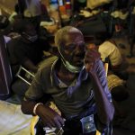 
              An elderly man drinks water inside a shelter for displaced Haitians, in Port-au-Prince, Haiti, Saturday, July 10, 2021, three days after Haitian President Jovenel Moise was assassinated in his home. The displaced Haitians were forced to flee their community where they had settled after the 2010 earthquake, after armed gangs set their homes on fire in late June. (AP Photo/Fernando Llano)
            