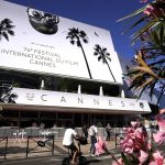 
              FILE - In this July 5, 2021 file Members of the pass in front of the Palais des Festival prior to the 74th international film festival, Cannes, southern France. (AP Photo/Brynn Anderson, File)
            