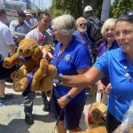 
              Jody Lockwood with the Lutheran Church Charities hands out teddy bears to firefighters after they finished their shift working in the rubbles of the Champlain Towers South collapse Thursday July 8, 2021 in Surfside, Fla. Rescue workers now focused on finding remains instead of survivors in the rubble of a Florida condominium collapse paused briefly atop the pile Thursday to mark the two-week anniversary of the disaster but said they had no plans to pull back during the recovery effort.  (Pedro Portal/Miami Herald via AP)
            