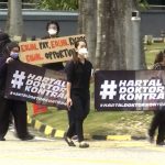 
              In this image from video, doctors hold banners in Malay that read “Contract Doctors Walkout” while participating  in a walkout held at the Sungai Buloh Hospital in Selangor, Malaysia Monday, July 26, 2021. Scores of doctors staged walkouts from Malaysian government hospitals on Monday, demanding fairer treatment for more than 20,000 contract doctors who play a key role in the fight against the worsening coronavirus pandemic. (AP Photo)
            