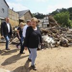 
              German Chancellor Angela Merkel, center, informs herself in the district of Iversheim about the situation in the flood-affected area and meet victims of the flood disaster Tuesday, July 20, 2021. (Wolfgang Rattay/Pool Photo via AP)
            