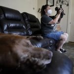 
              Roxanne Schaefer, of West Warwick, R.I., lifts a kitten while sitting near a family dog, a 15-year-old Labrador mix named Marvel, Tuesday, July 27, 2021, at her apartment, in West Warwick. Schaefer, who is months behind on rent, is bracing for the end to a CDC federal moratorium Saturday, July 31, 2021, a move that could result in millions of people being evicted just as the highly contagious delta variant of the coronavirus is rapidly spreading. (AP Photo/Steven Senne)
            