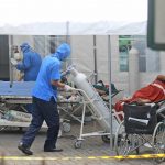 
              A medical worker wheels an oxygen tank to be used to treat patients at an emergency tent erected to accommodate a surge in COVID-19 cases, at Dr. Sardjito Central Hospital in Yogyakarta, Indonesia, Sunday, July 4, 2021. A number of COVID-19 patients died amid an oxygen shortage at the hospital on the main island of Java following a nationwide surge of coronavirus infections. (AP Photo/Kalandra)
            