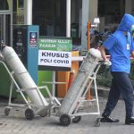 
              Medical workers wheel oxygen tanks at Dr. Sardjito Central Hospital in Yogyakarta, Indonesia, Sunday, July 4, 2021. A number of COVID-19 patients died amid an oxygen shortage at the hospital on the main island of Java following a nationwide surge of coronavirus infections. (AP Photo/Kalandra)
            