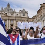 
              Members of Italian Cuban community show flags and banners reading in Spanish "freedom for Cuba" before Pope Francis' Angelus noon prayer from the window of his studio overlooking St.Peter's Square, at the Vatican, Sunday, July 18, 2021. The pope cited unrest in Cuba, expressing a prayer so that Cubans have a “more just and fraternal society.” (AP Photo/Alessandra Tarantino)
            