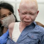 
              Baraka Cosmas, 12, cries on the lap of Elissa Montanti, founder and director at The Global Medical Relief Fund, left, after he receives a COVID-19 vaccination at Richmond University Medical Center, Friday, June 4, 2021, in the Staten Island borough of New York. Some of the children brought to the hospital in Montanti's group, all amputees who have faced severe trauma in their lives, were nervous before receiving the injection in an unfamiliar setting. (AP Photo/John Minchillo)
            