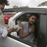 
              A woman receives the Sinovac COVID-19 vaccine from a health worker at a drive-through vaccination center, in Karachi, Pakistan, Saturday, July 31, 2021. (AP Photo/Fareed Khan)
            