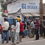 People wait for their turn to refill their oxygen tanks at a recharging station in Jakarta, Indonesia, Friday, July 9, 2021. Just two months ago, Indonesia was coming to a gasping India's aid with thousands tanks of oxygen. Now, the Southeast Asia country is running out of oxygen as it endures a devastating wave of coronavirus cases and the government is seeking emergency supplies from other countries, including Singapore and China. (AP Photo/Tatan Syuflana)
