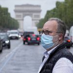 
              A man wearing a face masks to protect against coronavirus crosses the Champs Elysees avenue in Paris, Monday, July 12, 2021. France's President Emmanuel Macron is hosting a top-level virus security meeting Monday morning and then giving a televised speech Monday evening, the kind of solemn speech he's given at each turning point in France's virus epidemic. (AP Photo/Michel Euler)
            